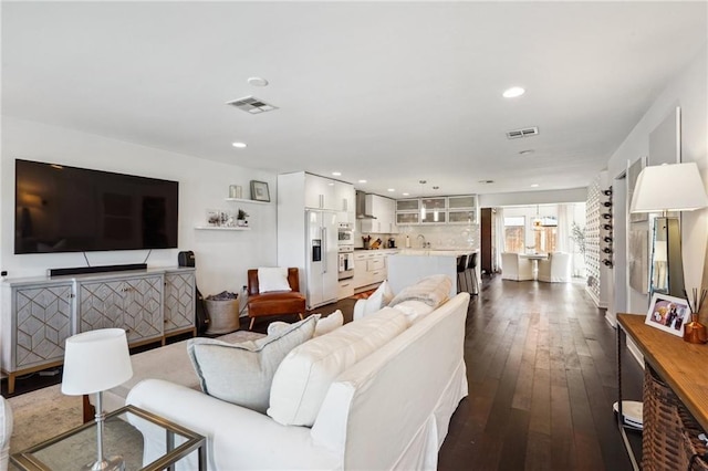 living room featuring visible vents, dark wood finished floors, and recessed lighting