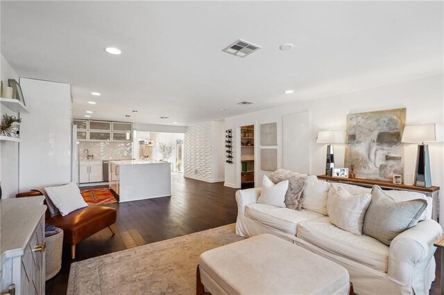 living room featuring dark wood-type flooring, visible vents, and recessed lighting