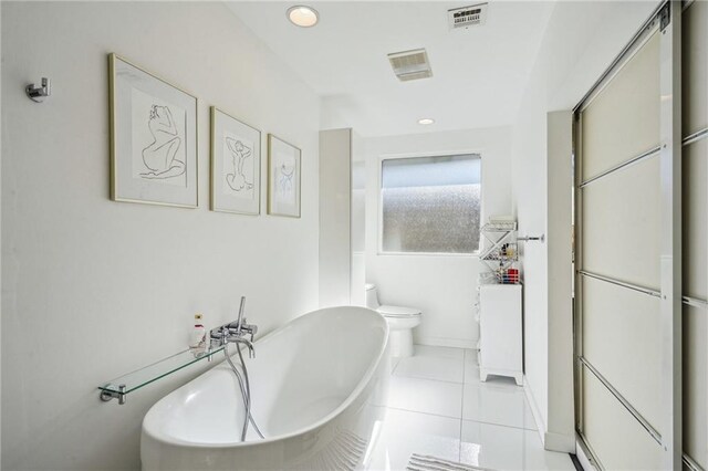 bathroom with visible vents, toilet, a bathing tub, tile patterned floors, and recessed lighting