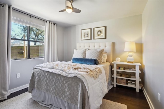 bedroom featuring a ceiling fan, baseboards, and wood finished floors