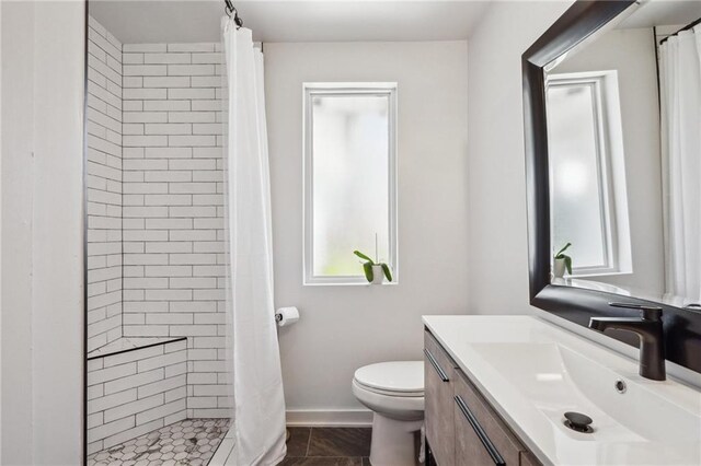 full bathroom with vanity, a shower stall, toilet, and baseboards