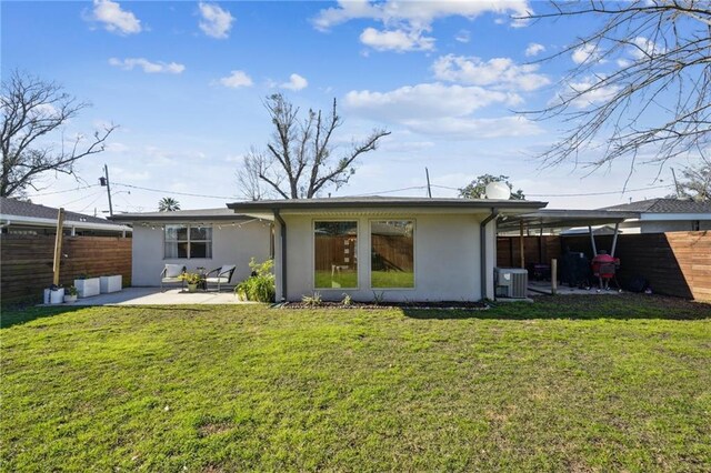 back of house with stucco siding, central AC, fence, and a lawn