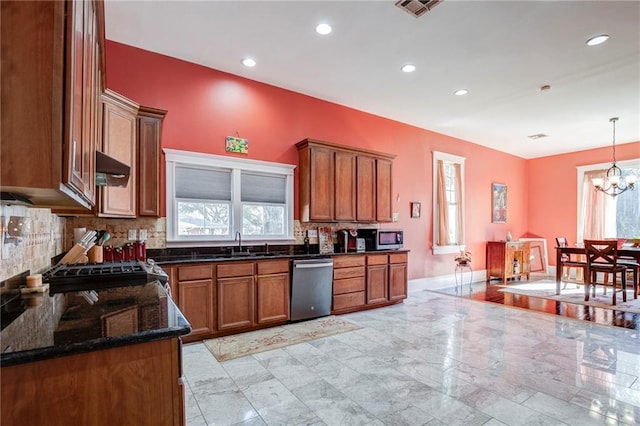 kitchen with decorative backsplash, brown cabinetry, stainless steel appliances, under cabinet range hood, and a sink