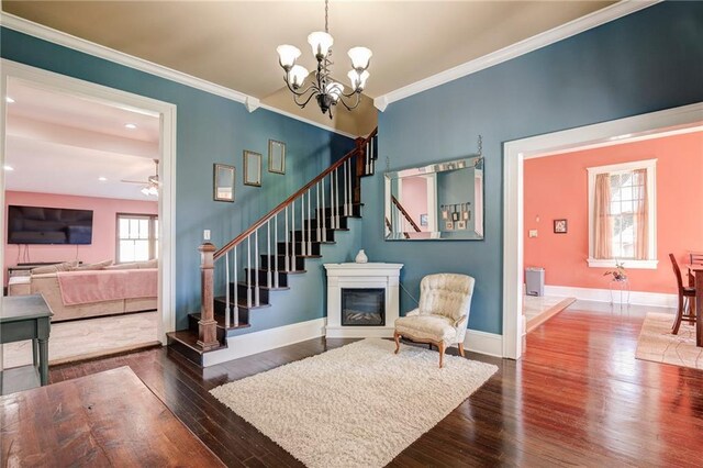 interior space with baseboards, dark wood-type flooring, stairway, and crown molding