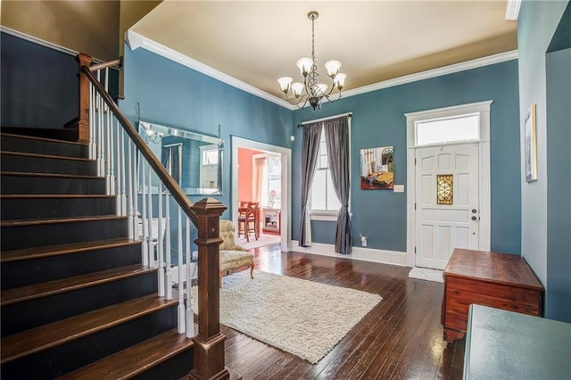 entrance foyer featuring a notable chandelier, baseboards, ornamental molding, stairway, and dark wood-style floors