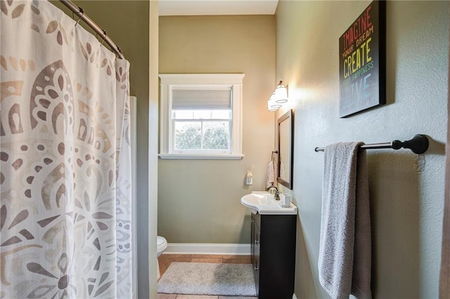 bathroom with a shower with shower curtain, toilet, vanity, baseboards, and tile patterned floors