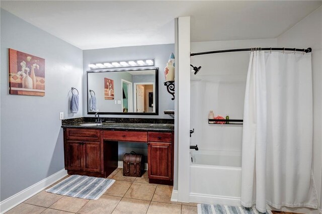 bathroom with shower / tub combo, tile patterned flooring, vanity, and baseboards