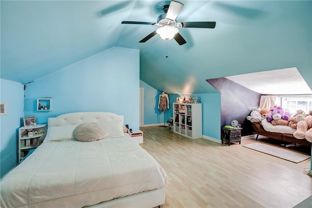 bedroom featuring baseboards, visible vents, a ceiling fan, wood finished floors, and vaulted ceiling