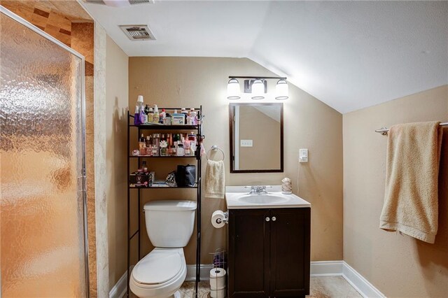 bathroom with lofted ceiling, toilet, vanity, visible vents, and a stall shower