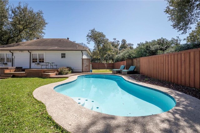 view of pool featuring a wooden deck, a lawn, a fenced backyard, and a fenced in pool