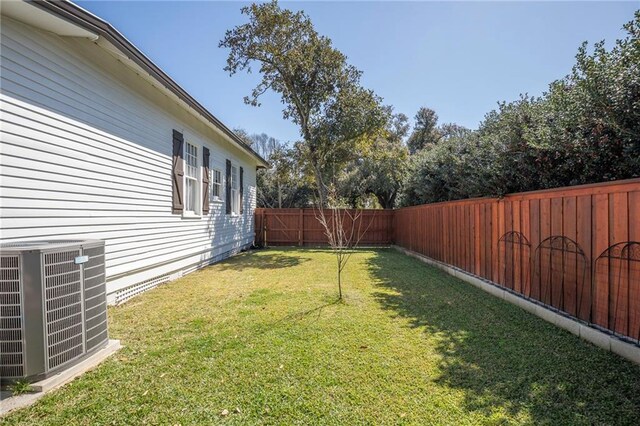 view of yard with a fenced backyard and central air condition unit