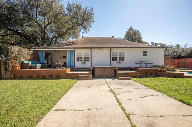 rear view of property with fence, a deck, a yard, a patio area, and an outdoor living space