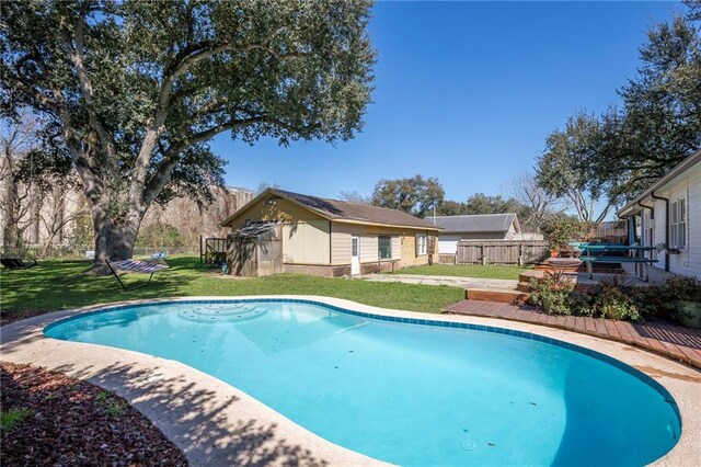 view of swimming pool with a fenced in pool, a yard, a wooden deck, and fence