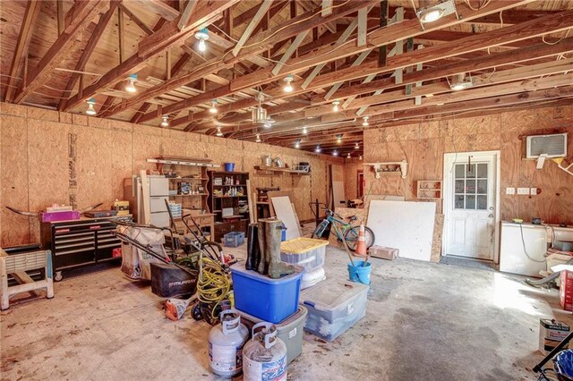 garage featuring a workshop area and freestanding refrigerator