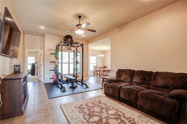 living room featuring recessed lighting, light tile patterned flooring, baseboards, and ceiling fan with notable chandelier