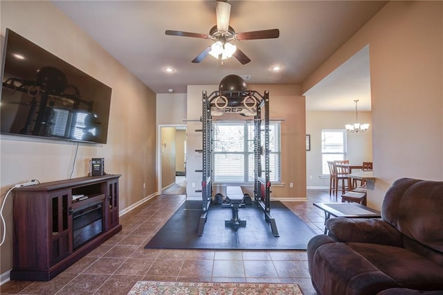 exercise room featuring tile patterned flooring, recessed lighting, baseboards, and ceiling fan with notable chandelier