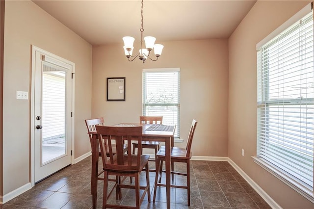 dining room featuring a chandelier and baseboards