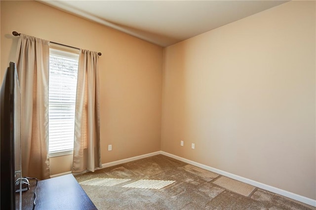 unfurnished room with carpet floors, a healthy amount of sunlight, and baseboards