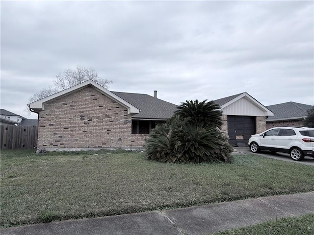 view of front of house featuring a garage, brick siding, and a front lawn