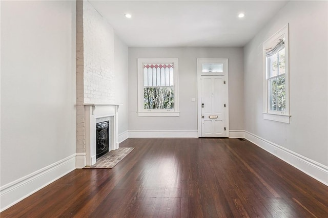 unfurnished living room featuring a fireplace, baseboards, wood finished floors, and recessed lighting