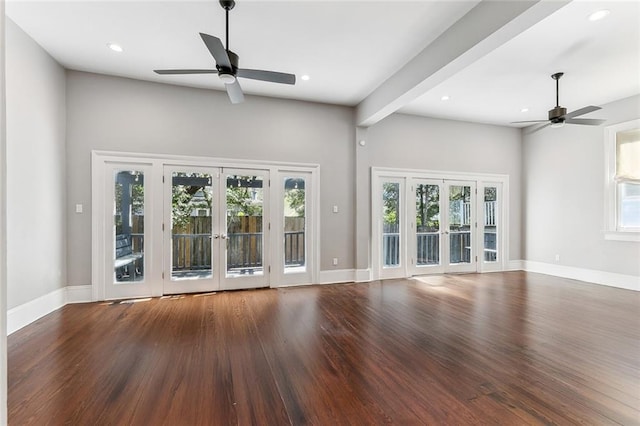 unfurnished living room featuring french doors, wood finished floors, and a wealth of natural light