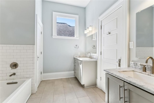 bathroom featuring a tub, tile patterned flooring, two vanities, and a sink