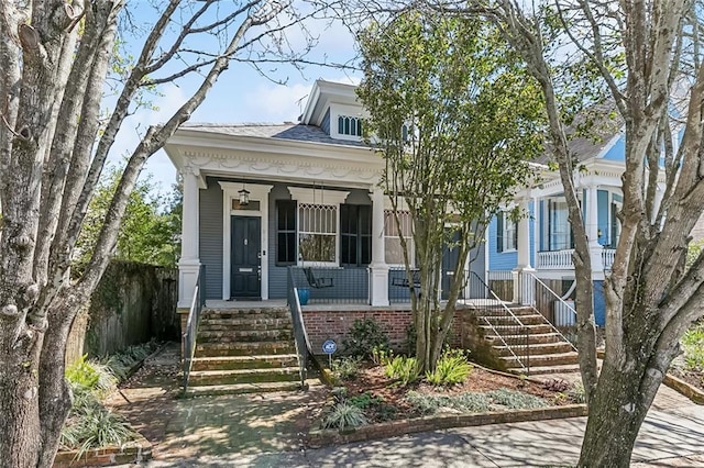 view of front facade featuring covered porch and stairway