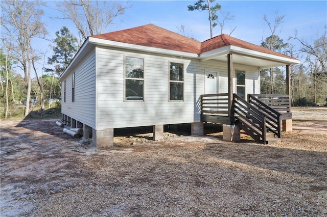 rear view of house with roof with shingles