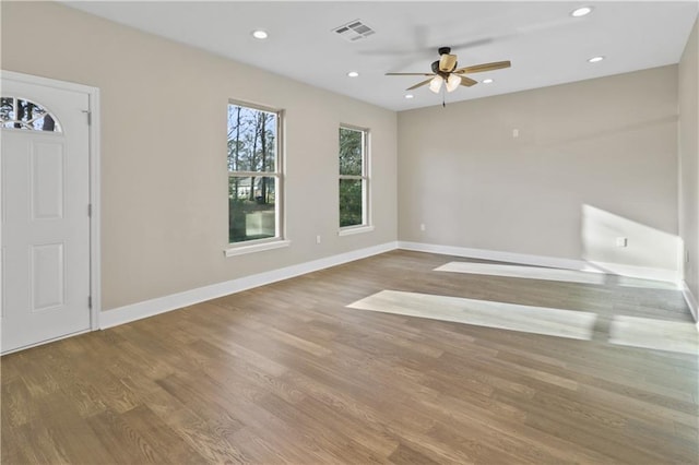 interior space featuring wood finished floors, visible vents, ceiling fan, and baseboards