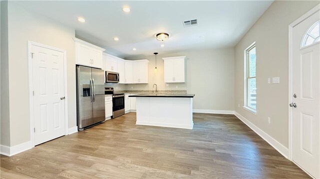 70378 C St, Covington, LA 70433 - kitchen with appliances with stainless steel finishes, healthy amount of natural light, light wood-type flooring, white cabinets, and recessed lighting