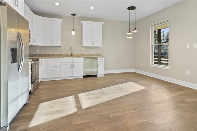kitchen with white cabinetry, stainless steel appliances, baseboards, light wood-type flooring, and recessed lighting