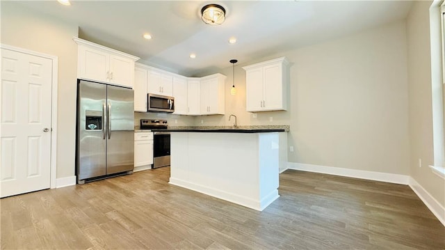 70378 C St, Covington, LA 70433 - kitchen with stainless steel appliances, light wood-style floors, white cabinetry, pendant lighting, and recessed lighting