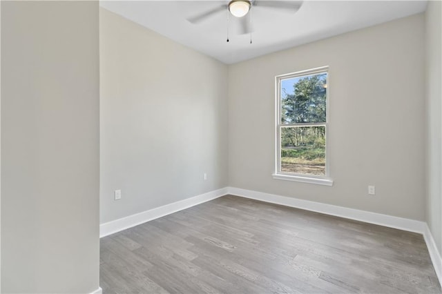 unfurnished room featuring baseboards, wood finished floors, and a ceiling fan