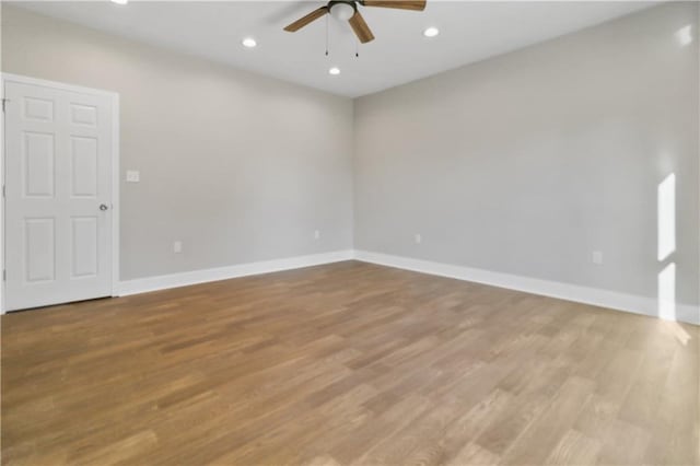 spare room with ceiling fan, wood finished floors, and baseboards