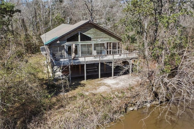 rear view of house featuring a wooded view and a wooden deck