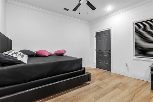 bedroom featuring light wood finished floors, visible vents, ornamental molding, ceiling fan, and baseboards