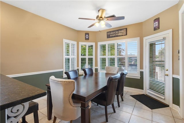 dining space with ceiling fan, light tile patterned floors, and baseboards