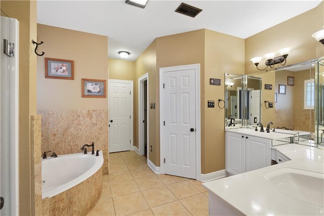 bathroom with tile patterned flooring, a garden tub, vanity, visible vents, and baseboards