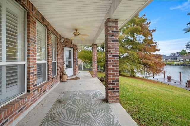 view of patio / terrace featuring a water view and ceiling fan