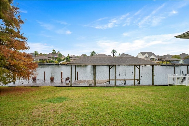 view of dock featuring a lawn, a water view, and a residential view