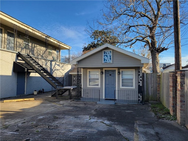 view of front of property featuring stairway and fence