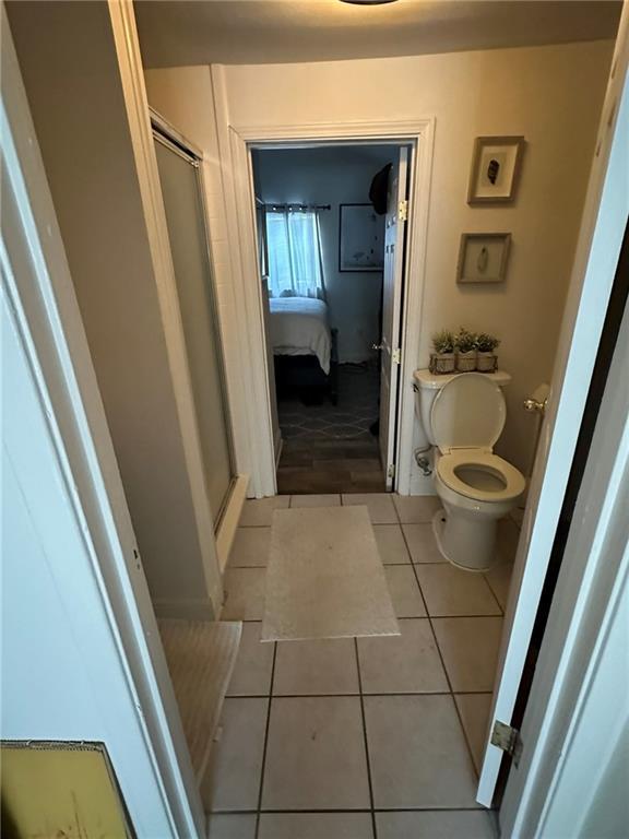 full bathroom with tile patterned floors, toilet, and a shower stall