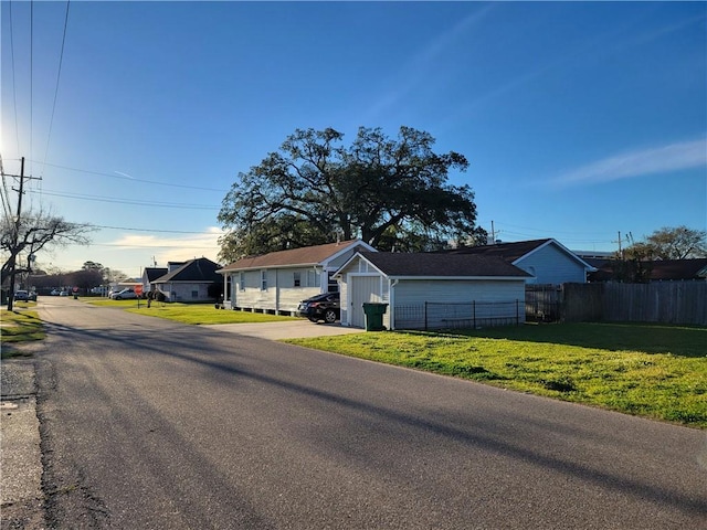 single story home featuring a residential view, a front yard, and fence