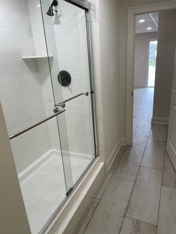 bathroom with a stall shower and baseboards