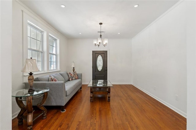 entrance foyer with wood finished floors, visible vents, baseboards, ornamental molding, and an inviting chandelier