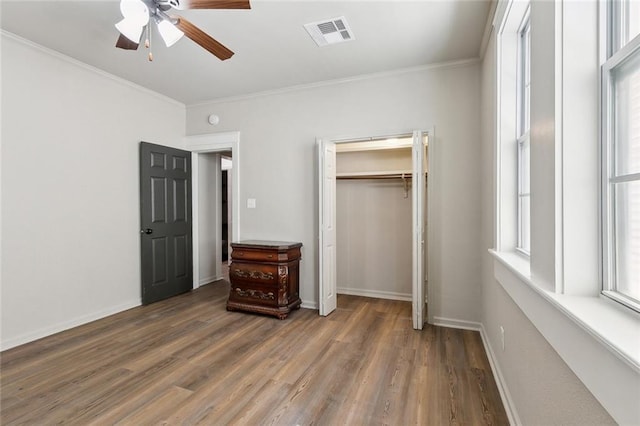 bedroom featuring baseboards, visible vents, wood finished floors, and ornamental molding