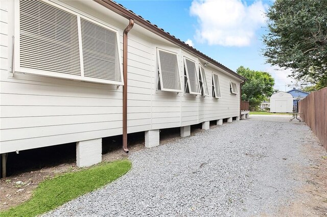 view of property exterior with driveway and fence