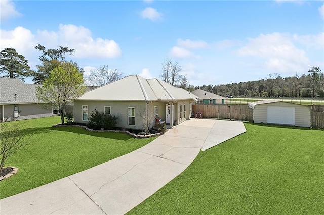 ranch-style home with a storage unit, fence, an outdoor structure, and a front yard