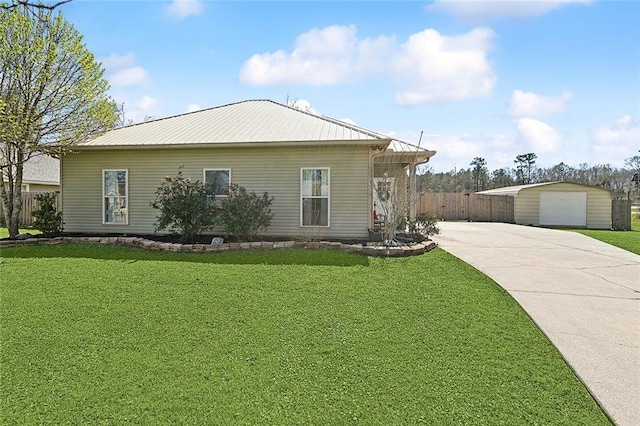 view of home's exterior with fence, metal roof, a lawn, and an outbuilding