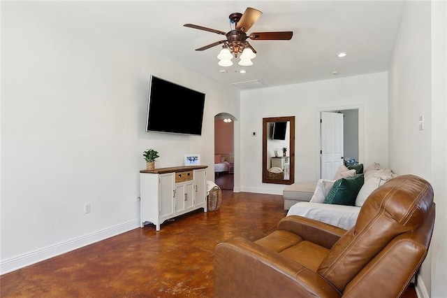 living room featuring arched walkways, finished concrete flooring, recessed lighting, a ceiling fan, and baseboards